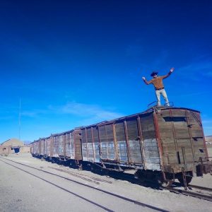 Lukas Zettl bei seiner Tour durch Südamerika auf einem stillgelegten Waggon. Wanderhunger, 7 Fragen