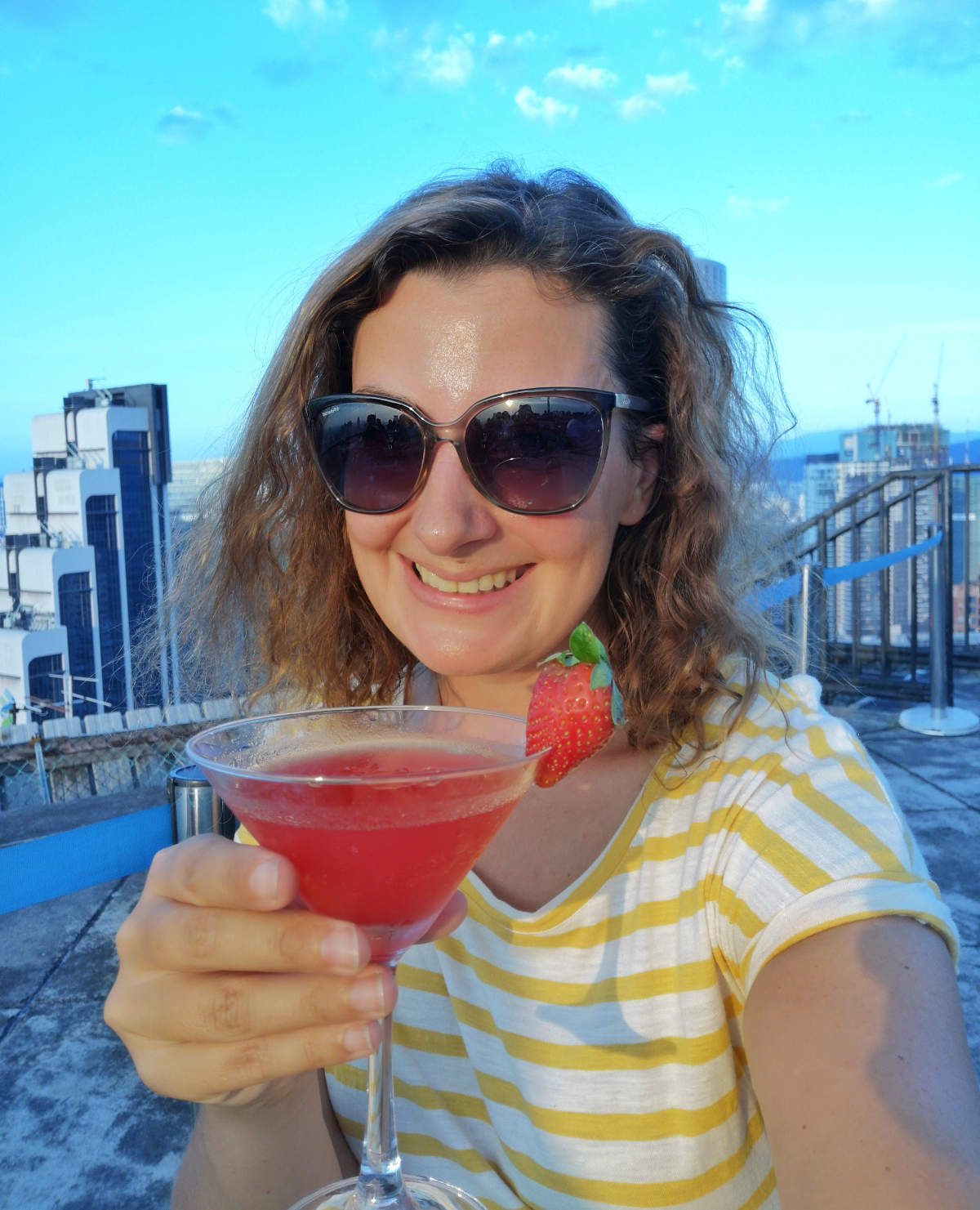 Ich genieße eine Strawberry Margarita zum Happy Hour Preis auf der Heli Lounge Bar in Kuala Lumpur, einer Cocktailbar auf einem Helikopter Landeplatz. Wanderhunger