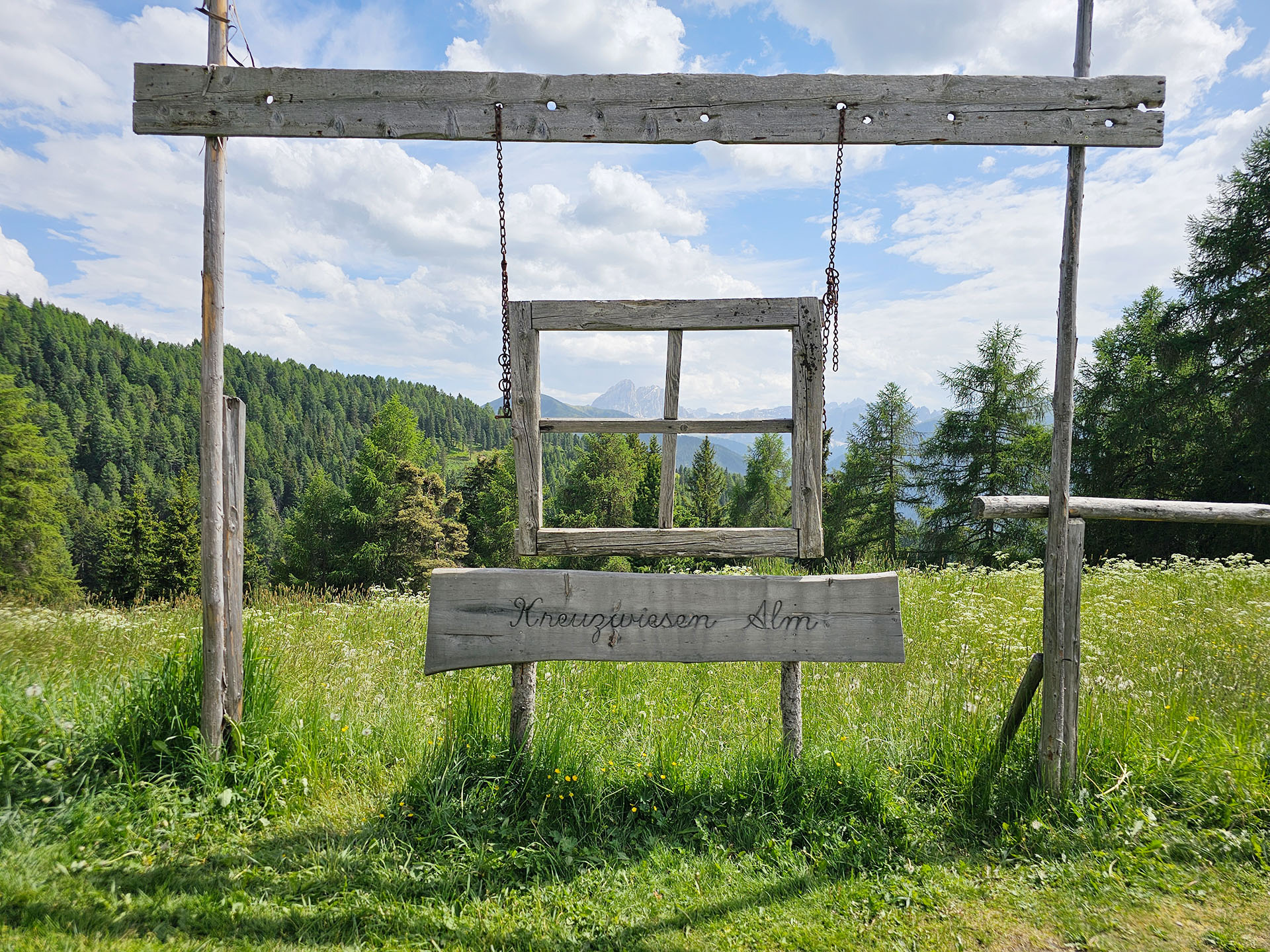 Gezimmertes Fenster als Aussichtspunkt auf einer Alm