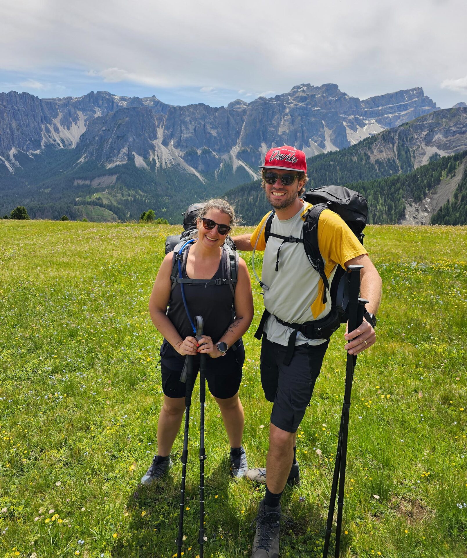 Ein Mann und eine Frau pasieren auf einer Almwiese für ein Foto