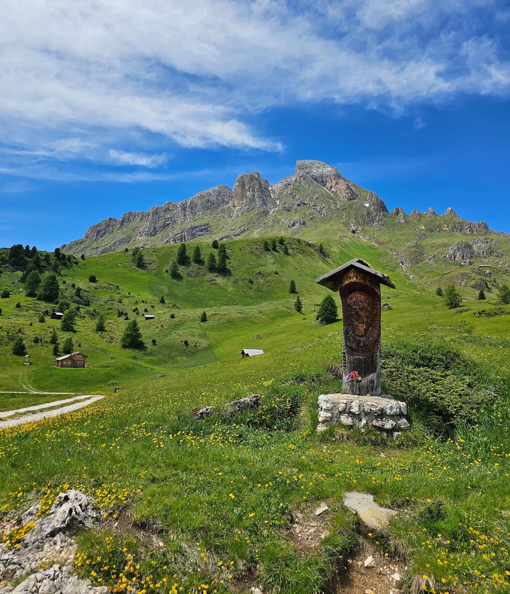 Almwiese mit Holzmarterl und Gipfel im Hintergrund