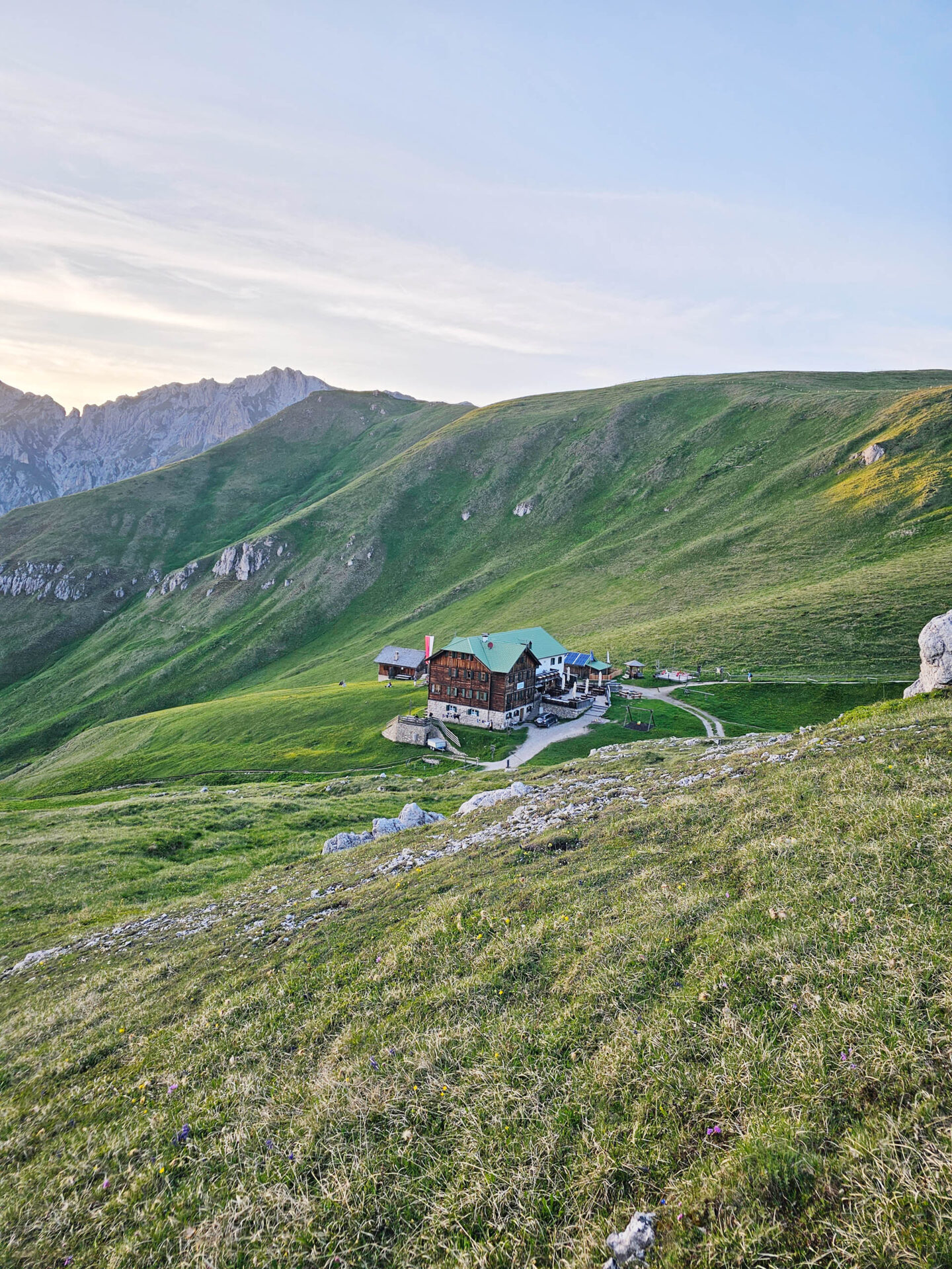 Berghütte eingebettet in abfallende Almwiesen