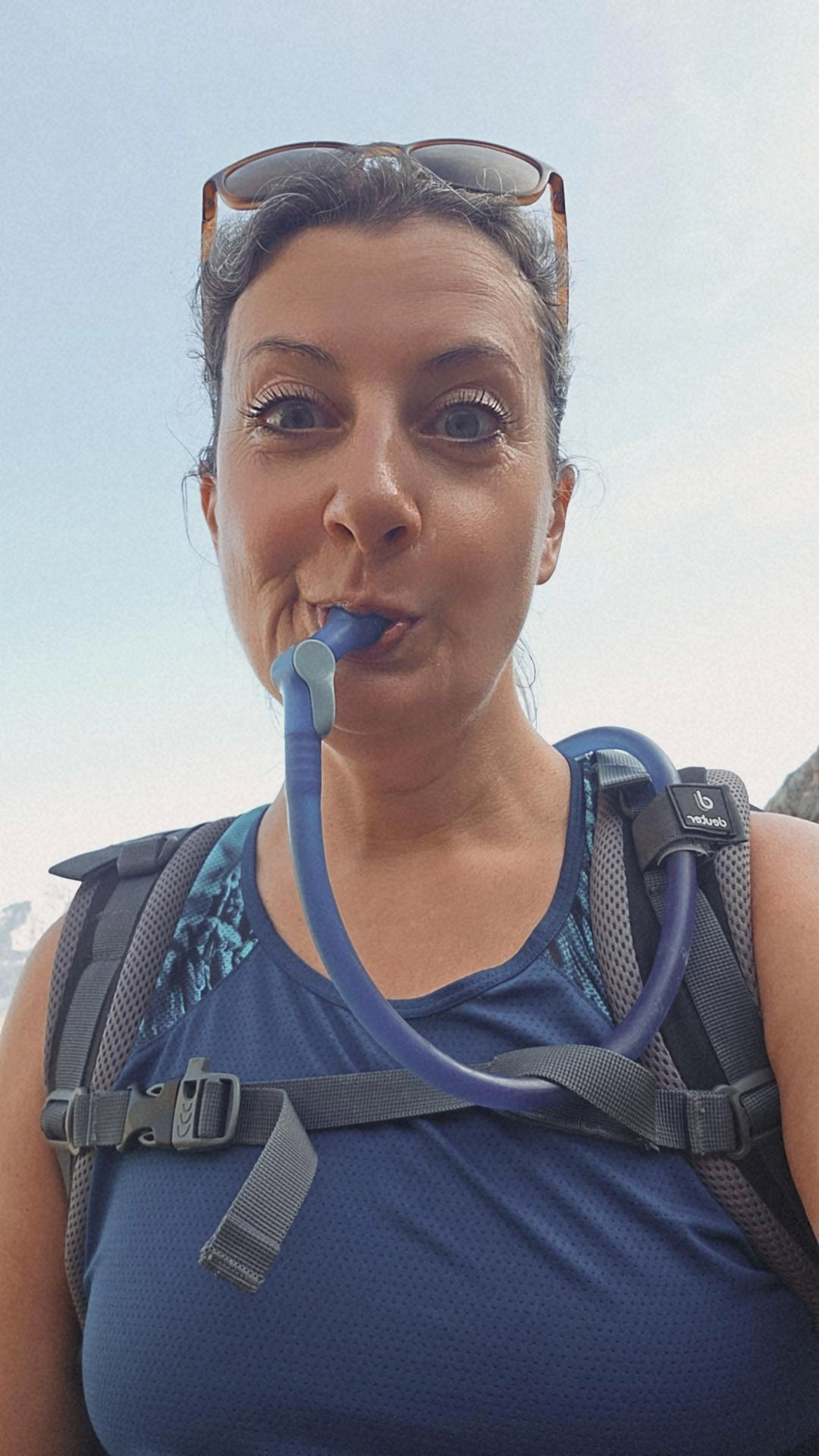 Frau trinkt aus einem Wasserschlauch eines Trinksystems