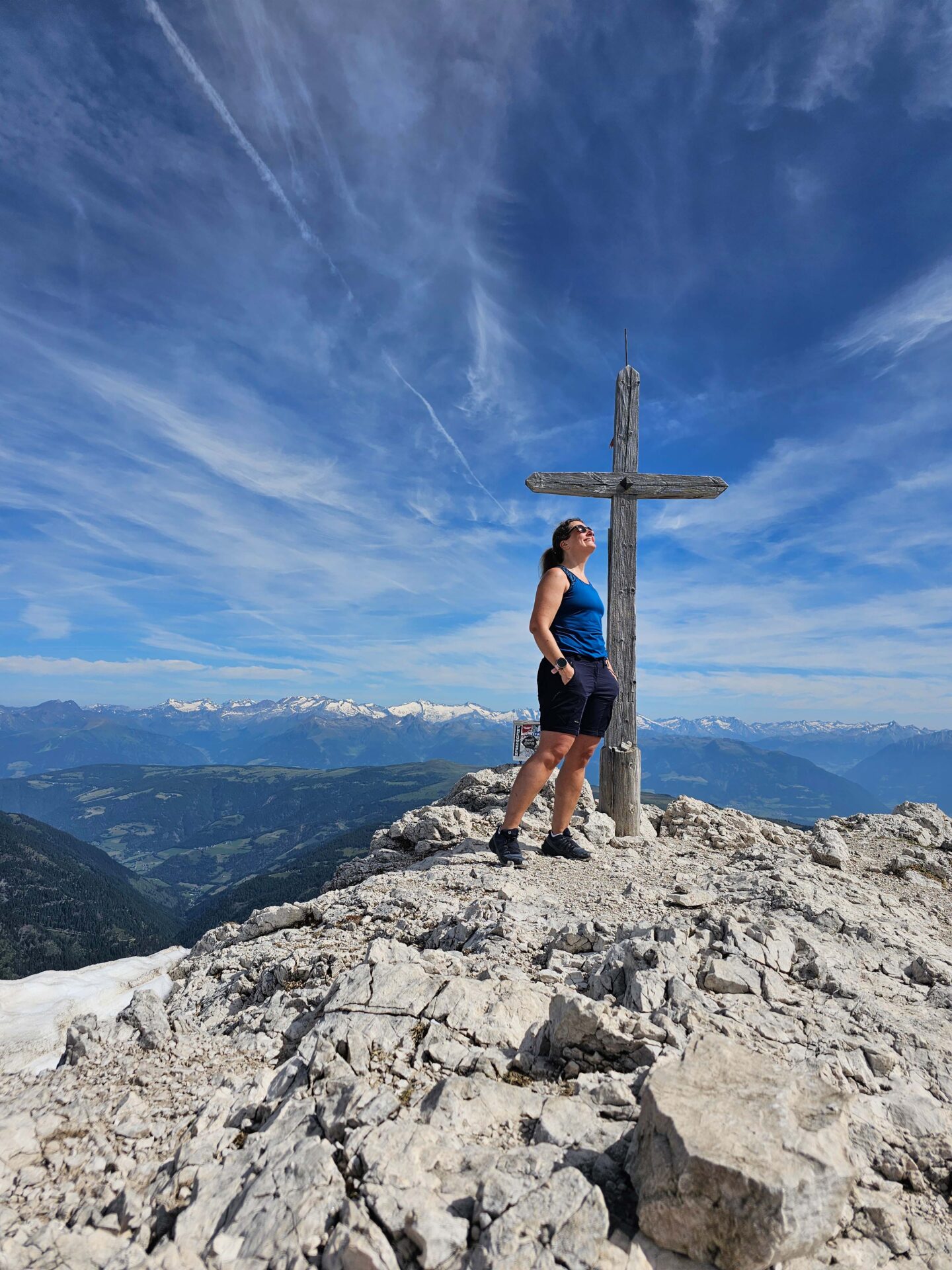 Frau vor einem Gipfelkreuz am Peitlerkofel