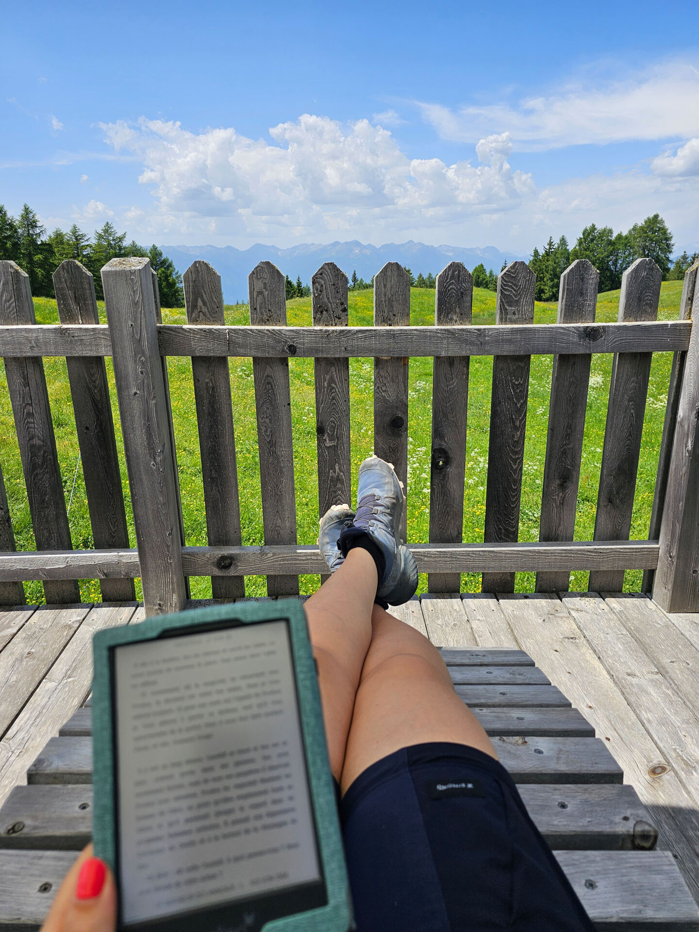 Foto von e-Book-Reader und Beinen mit Aussicht auf Gebirgszug