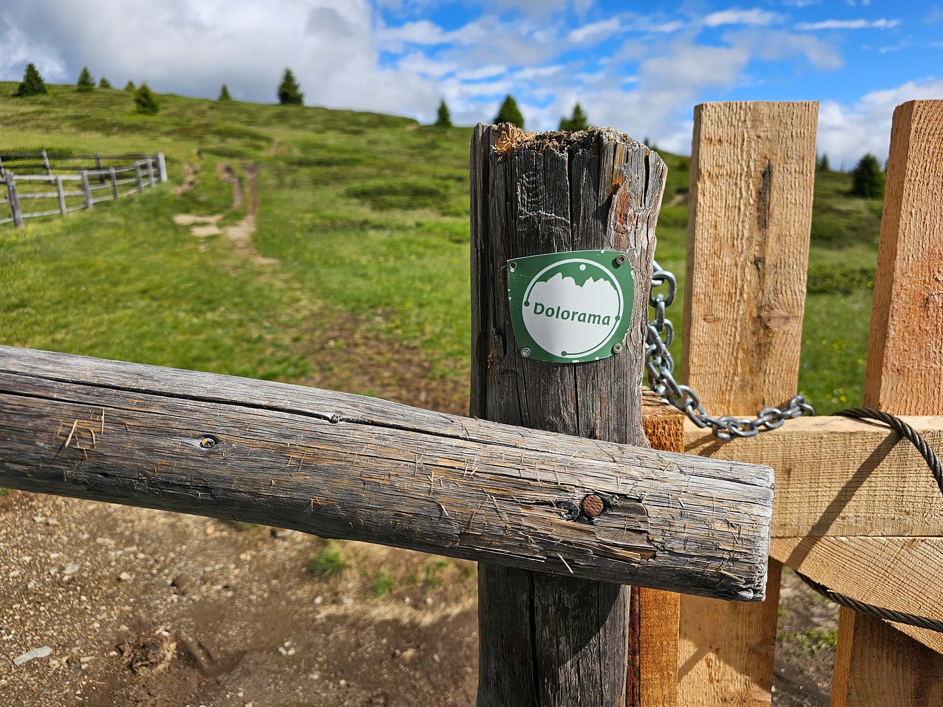 Plakette mit Bezeichnung Dolorama auf einem Holzzaun auf einer Alm