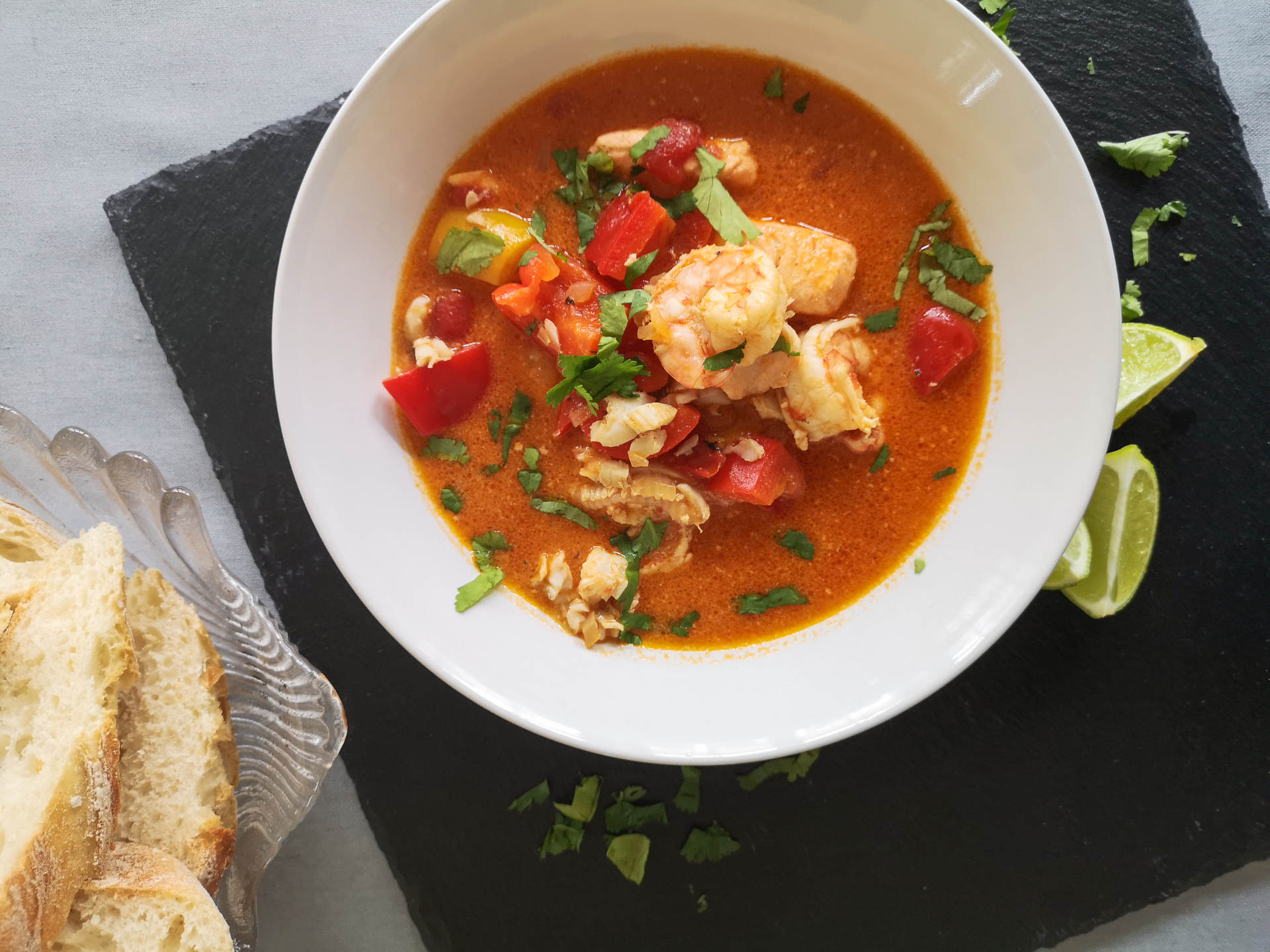 Fischsuppe in weißem Teller mit Weißbrot