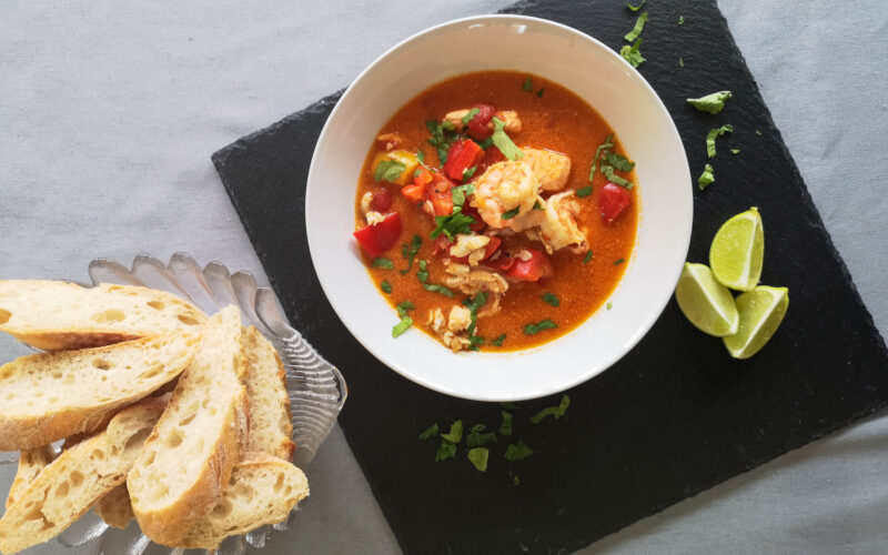 Fischsuppe in weißem Teller mit Weißbrot