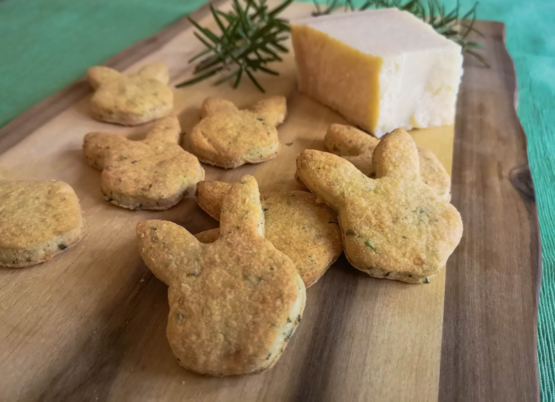 Parmesankekse auf Holzbrett mit Rosmarinzweig