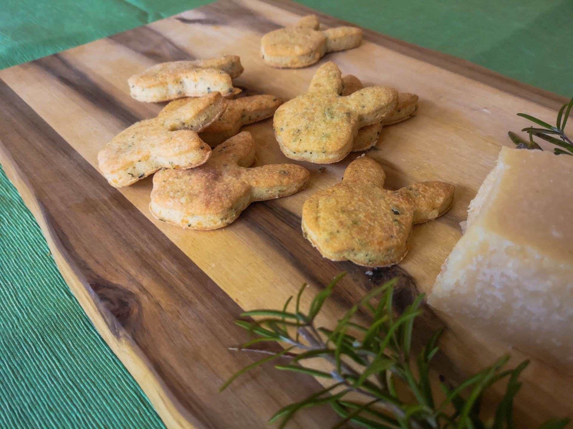 Parmesankekse auf Holzbrett mit Rosmarinzweig