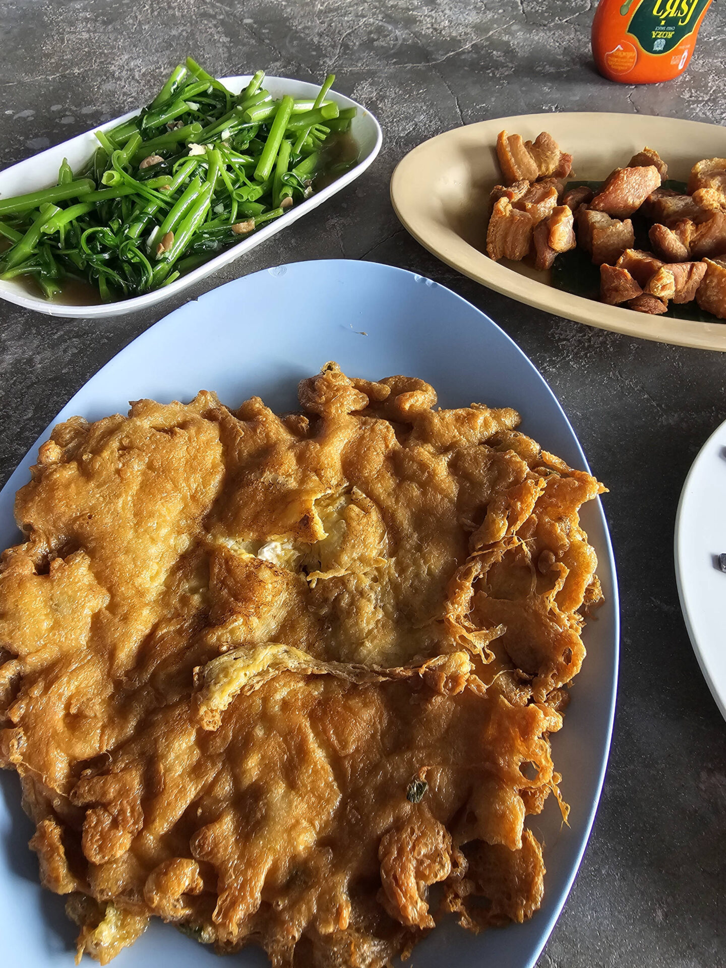 Thailändische Speisen: Morning Glory, Schweinebauch und Krabbenomelette